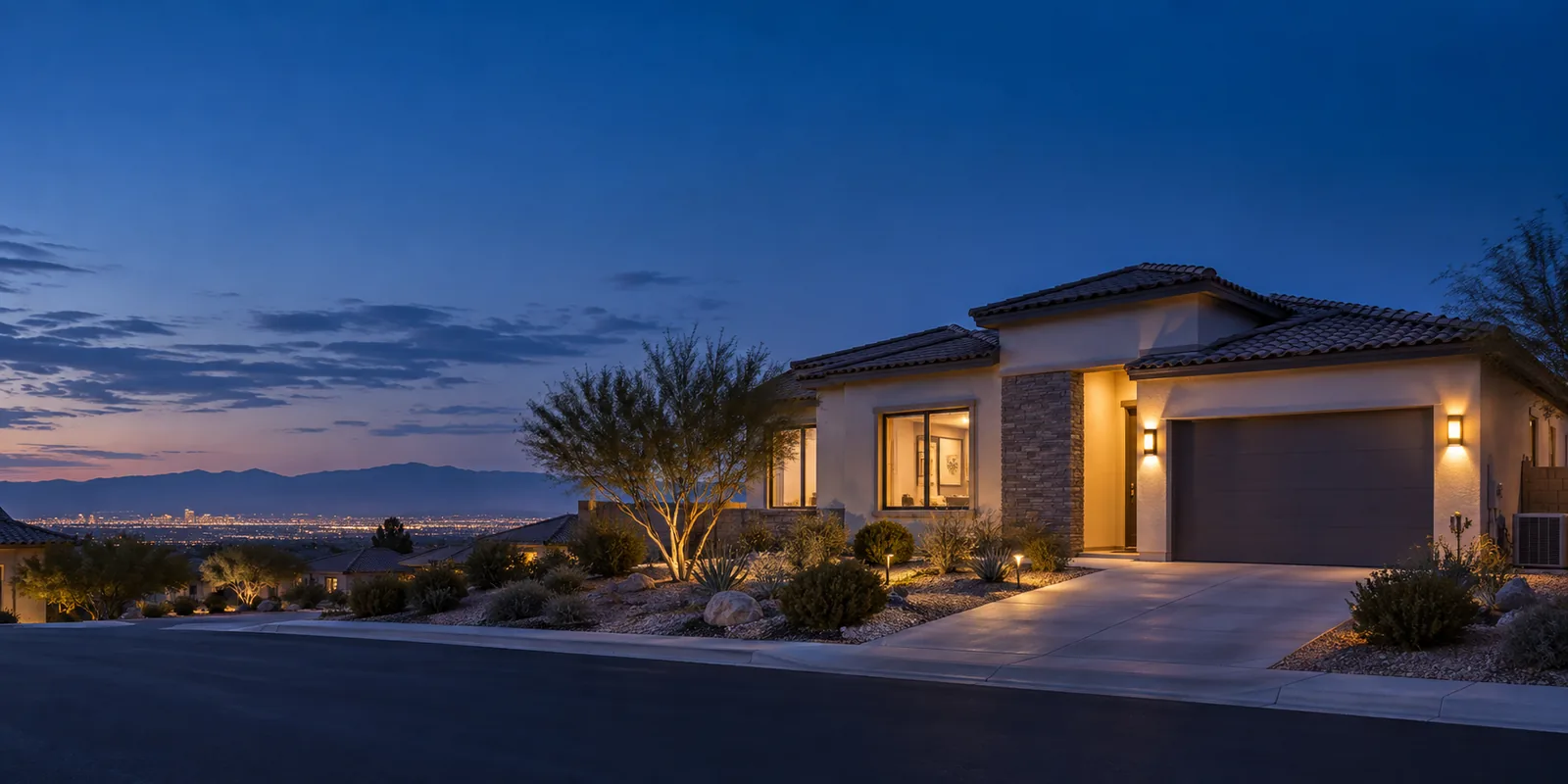 Modern home illuminated at dusk with city lights visible in distant valley below